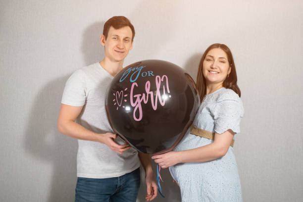 молодые родители с воздушным шаром узнают пол малыша - human pregnancy baby shower image color image стоковые фото и изображения