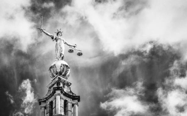 A black and white close up of the statue of Lady Justice, located on top of the Central Criminal Court, known as the Old Bailey, in London.