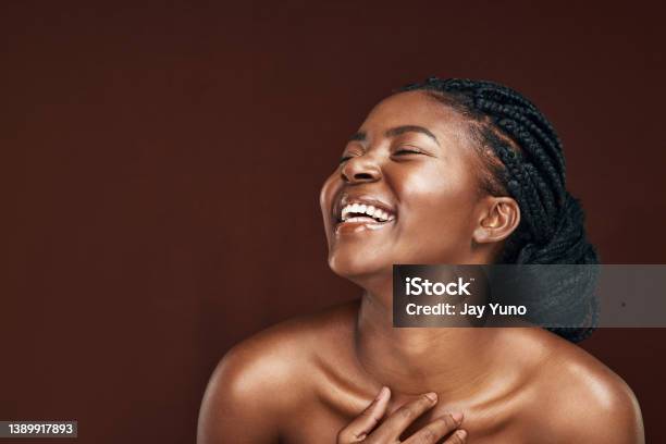 Studio Shot Of An Attractive Young Woman Posing Against A Brown Background Stock Photo - Download Image Now