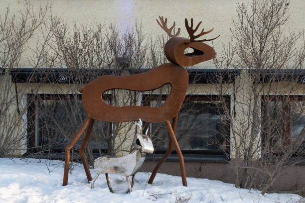 Rovaniemi, Finland - March 17th, 2022: Two metal reindeer sculptures on a Rovaniemi, Finland, street, on a winter day.