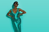Black fashion model is posing in a turquoise satin dress