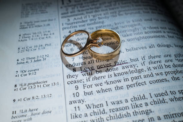 istock Gold Wedding Rings on a Bible with the Scripture Love Never Fails 1389922824