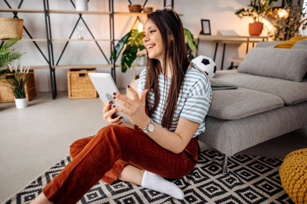 istock Cheerful woman using digital tablet at home 1389922924
