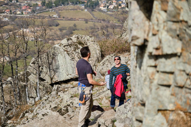 istock Cheerful men climbing rocks together in highlands 1389923082