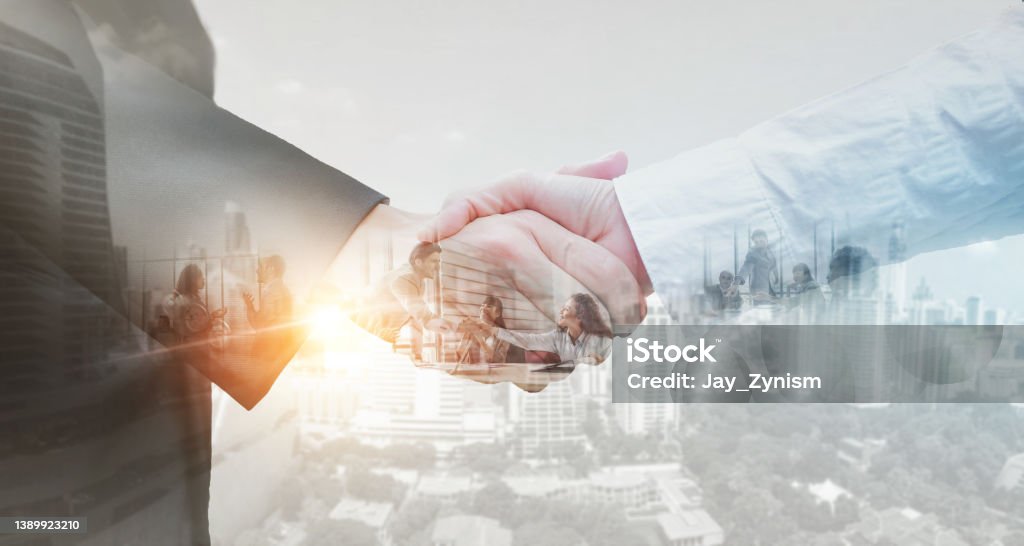 Business partner shaking hands in city with double exposure of interface data. Teamwork concept. Handshake Stock Photo