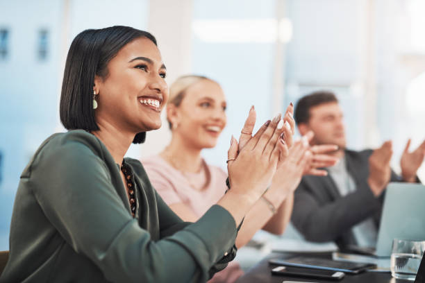 Shot of a group of businesspeople clapping during a meeting in a modern office stock photo