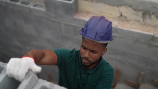 Construction worker building a brick wall