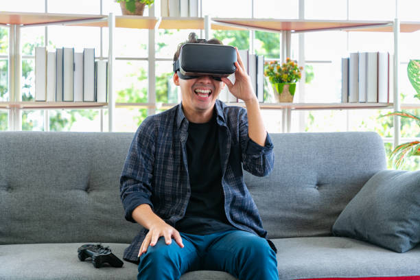 istock Happy young man watching with VR device in the living room. 1389925626