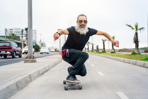 istock latin senior man skateboard on bikeway and having fun 1389925938