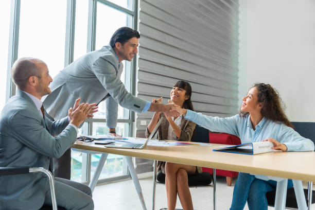 istock Young modern men is shaking hands and smiling while working in the creative office. Glad to work with you. 1389926531