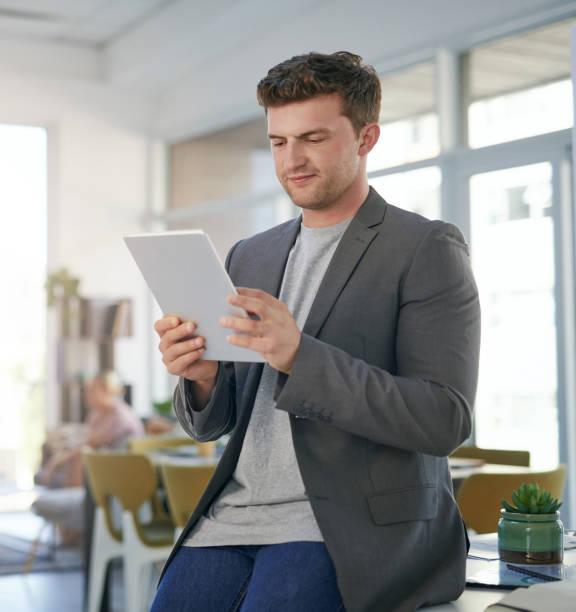 istock Shot of a young businessman using a digital tablet in a modern office 1389927340