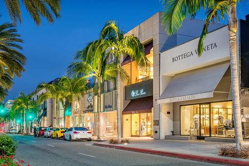Illuminated luxury stores on Rodeo Drive in Beverly Hills, Los Angeles, California, USA at night.