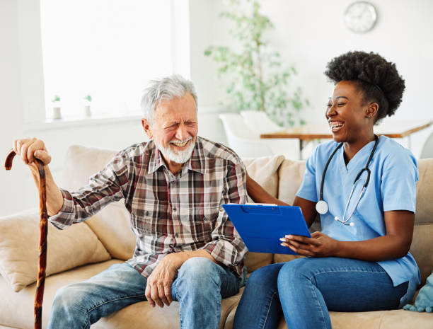nurse doctor senior care caregiver help assistence retirement home nursing elderly man woman health support african american black Doctor or nurse caregiver with senior man at home or nursing home home caregiver stock pictures, royalty-free photos & images