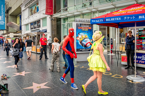 Costumed Street Performers walk in Hollywood, Los Angeles, California, USA on a cloudy day.