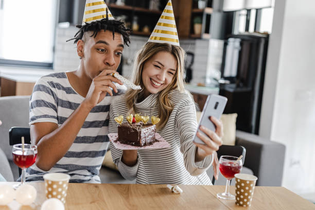 istock Young couple celebrating birthday at home and taking selfie 1389937101