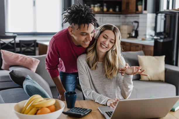 istock Young couple using laptop at home 1389937259