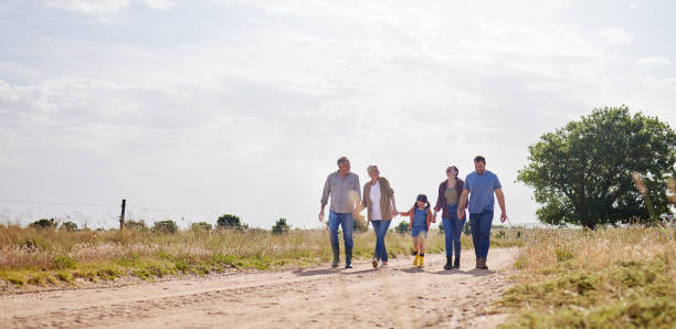 снимок семьи из нескольких поколений, идущей вместе по ферме - grandparent grandfather walking grandchild стоковые фото и изображения