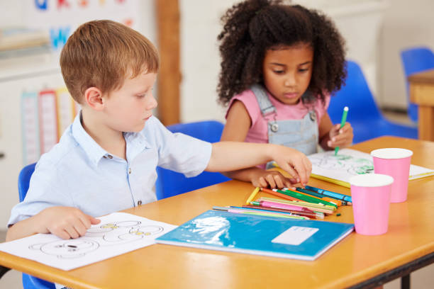 istock Shot of preschool students colouring in class 1389944261