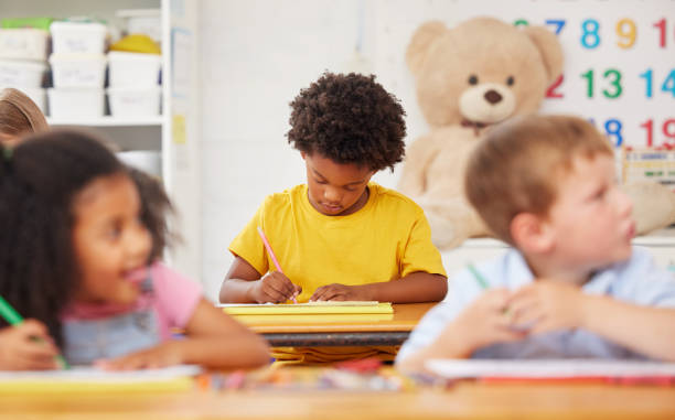 istock Shot of preschool students colouring in class 1389944264