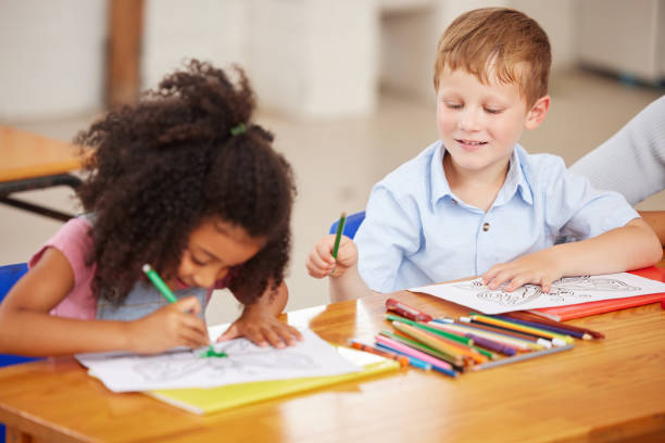 istock Shot of preschool students colouring in class 1389944269