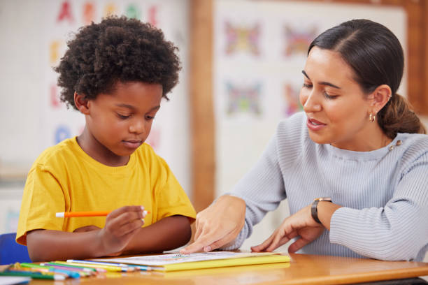 Shot of a female teacher assisting a preschool learner in her class I love the colours you've used here instructor stock pictures, royalty-free photos & images