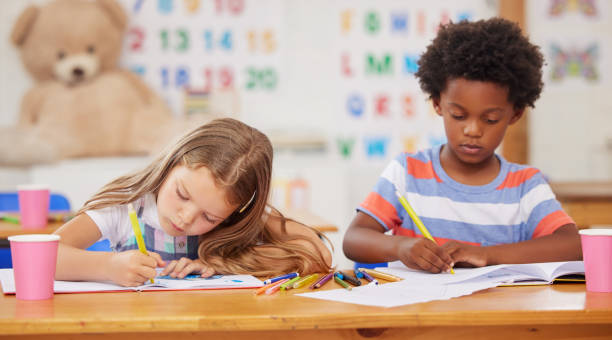 istock Shot of preschool students colouring in class 1389944313