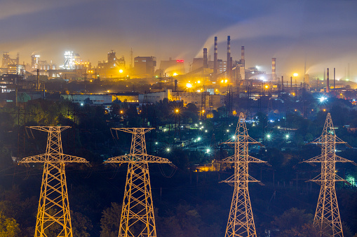 Industrial view with electric power lines and metallurgical plants at night