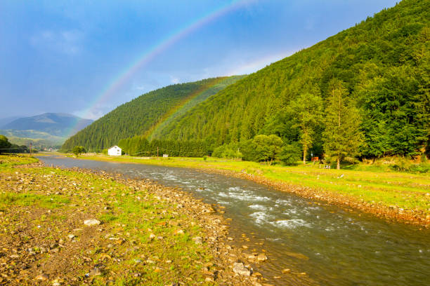 Twin rainbow over the mountain river in Carpathians, Ukraine