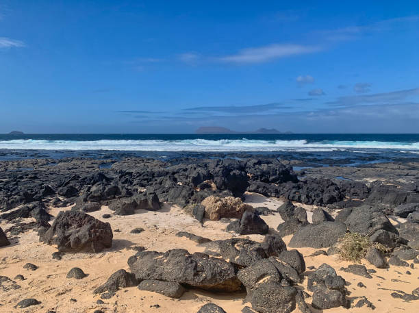 istock Rocks on a beach and Alegranza island 1389949138