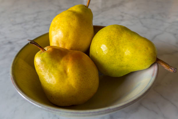 3 Pears Three delicious Bartlett pears in a bowl on a marble countertop bartlett pear stock pictures, royalty-free photos & images