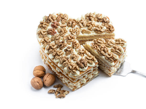 Homemade  Heart shaped layered cake decorated with walnuts isolated on white