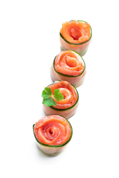 rollos de salmón con rodaja de pepino aislado sobre blanco - pink salmon fotografías e imágenes de stock