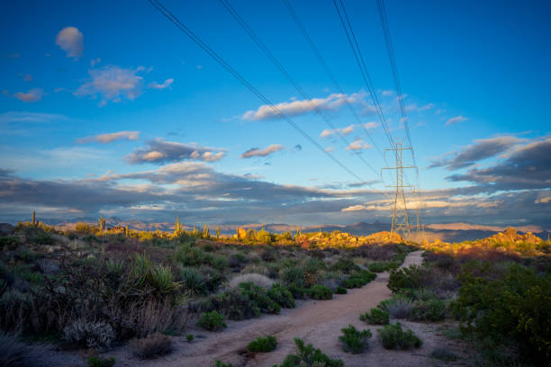 power lines running through scenic desert landscape during sunset