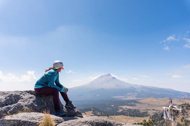 istock Female hiker looking at steaming volcano 1389950141