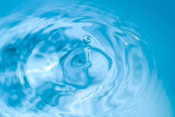istock water drop splash blue colored. Round water drop. Water drop in glass. Drops, splashes, spray, abstract shapes out of the water 1389951092