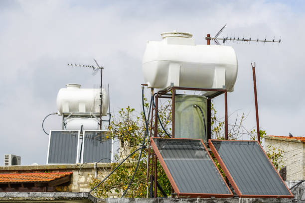 słoneczne systemy podgrzewania wody z dużymi zbiornikami wody i kotłami na dachu domu - decimeter zdjęcia i obrazy z banku zdjęć