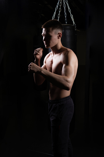 Athlete blows practices the boxer bag The glove black young professional body, for strong muscle for power from fit lifestyle, training sweat. Person victory dark,