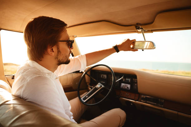 istock Young handsome man in sunglasses sitting inside his car 1389953258