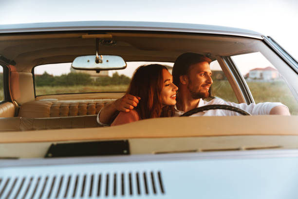 istock Smiling young couple hugging while sitting together inside a car 1389954238