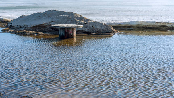 istock Empty bobbins for winding and transporting cable in lake. Environmental pollution by waste from laying communications. 1389954996