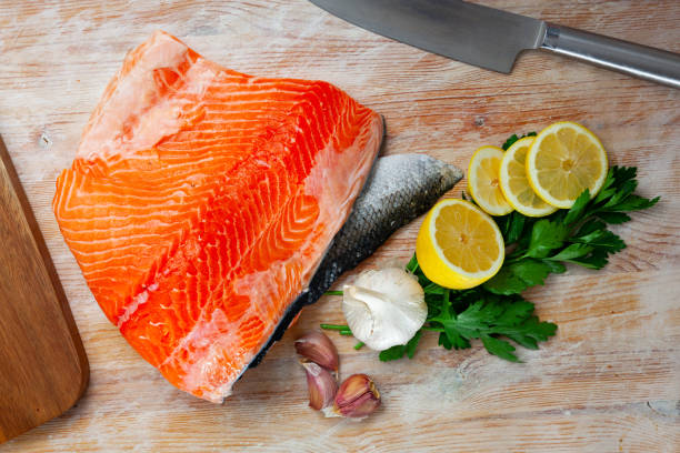 istock Raw salmon fillet with lemon and greens before cooking 1389955783