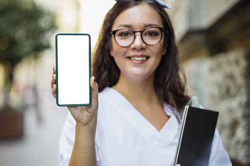 Photo of a young woman holding a smartphone with a blank screen