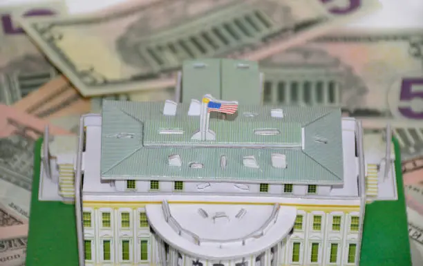 Photo of model of the White House of the President on the background of dollars
