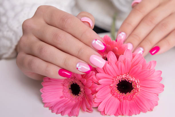 istock Female hands with pink manicure, flowers design 1389966271