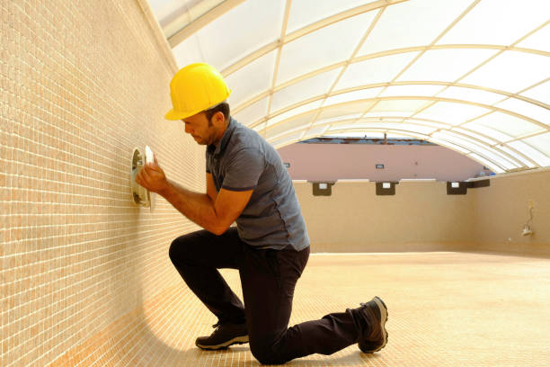 istock electrician with screwdriver fixes light bulb in an empty swimming pool under construction 1389966274