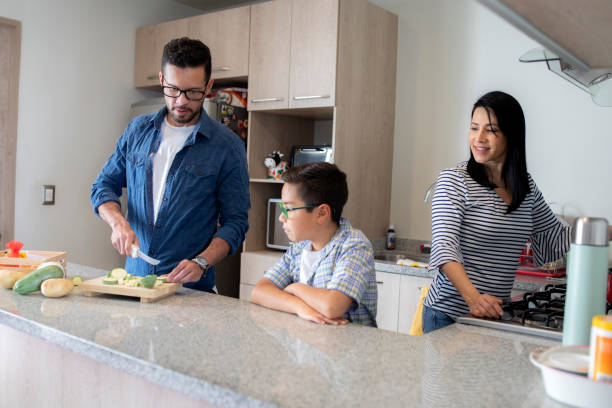 istock parents and child cooking at home 1389968803