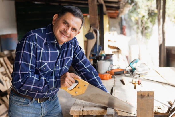 istock Hispanic man working with saw in his carpentry workshop-Latin Carpenter working 1389970326