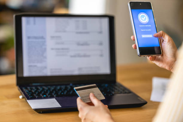 istock Young woman Paying Bills with mobile phone 1389971293