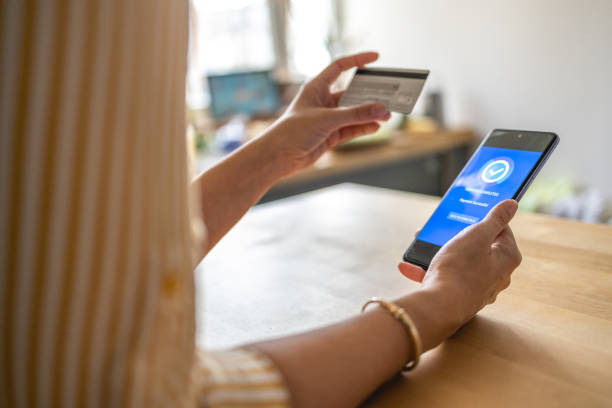 istock Young woman Paying Bills with mobile phone 1389971317