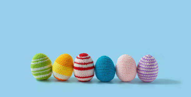 istock Happy Easter crochet composition. Easter eggs made in crochet and colored wool. Amigurumi eggs. Blue background with copy space 1389975158